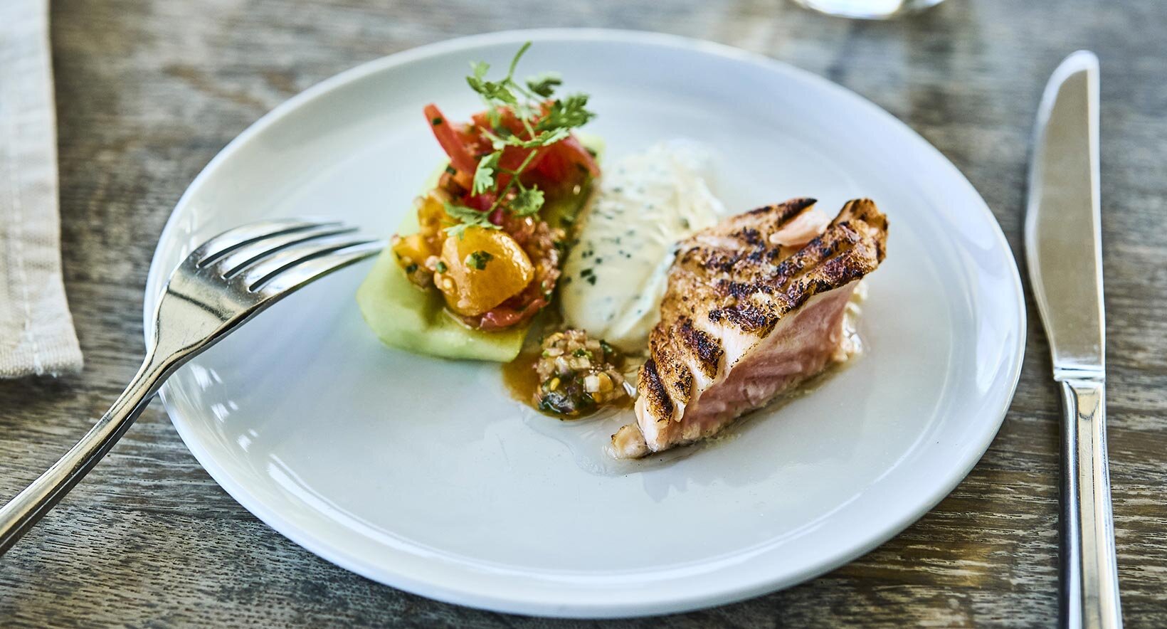 Grillet laks med tomatsalat og rømmedressing på tallerken. Foto: Tom Haga